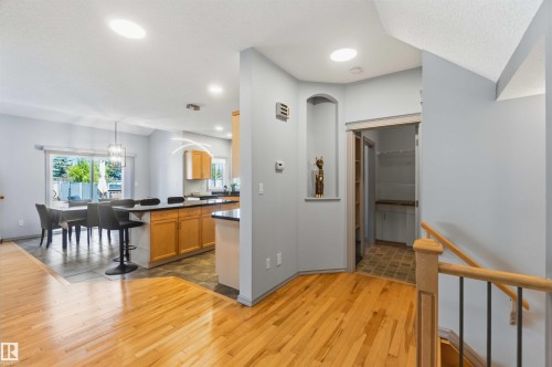Hardwood flooring extending to a kitchen and dining area with tile flooring - 3061 Spence Wynd, Edmonton, AB 