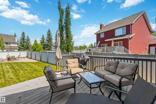 Expansive wood deck with dark railing, offering a direct walkout to a manicured lawn - 3061 Spence Wynd, Edmonton, AB 