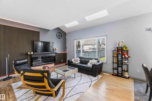 Vaulted ceiling living area featuring skylights and light wood-finish flooring - 3061 Spence Wynd, Edmonton, AB 