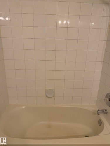 Alcove bathtub with white ceramic tile surround and chrome fixtures - 213 17467 98A Avenue, Edmonton, AB 
