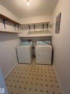 Utility room featuring a patterned floor, built-in shelving, and a ceiling-mounted light fixture - 