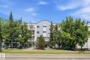 Four-story multi-unit building featuring a light-colored facade with blue trim accents and multiple private balconies - 105 11446 40 Avenue Nw, Edmonton, AB 