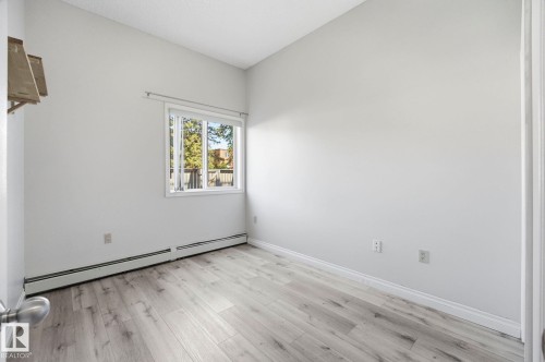 Room featuring light wood-finish flooring, white walls, and a window with white trim - 105 11446 40 Avenue Nw, Edmonton, AB 