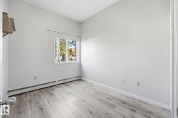 Room featuring light wood-finish flooring, white walls, and a window with white trim - 