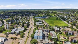 Expansive aerial perspective showcasing a verdant residential area with a prominent thoroughfare - 
