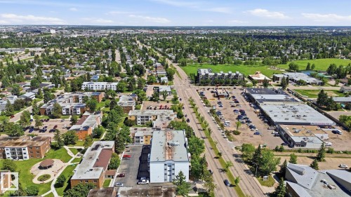 Expansive aerial perspective showcasing a neighborhood with diverse residential buildings and commercial structures - 105 11446 40 Avenue Nw, Edmonton, AB 