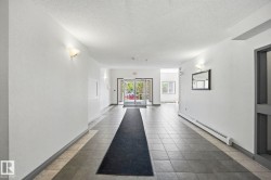 Entryway featuring geometric tile flooring, wall sconce lighting, and glass double doors - 