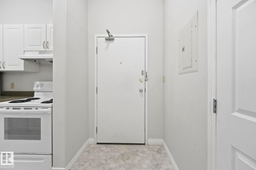 Entryway featuring hexagonal tile flooring and solid core entry door - 105 11446 40 Avenue Nw, Edmonton, AB 
