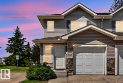 Exterior featuring horizontal siding, stone accents, and an attached garage with a paneled door - 