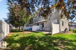Spacious grassy area featuring mature trees and a private patio with sliding glass door access to the interior - 