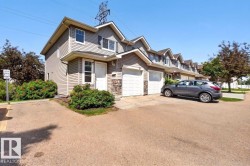 Two-story siding exterior with stone accenting, prominent front entry, attached garage, and mature landscaping - 