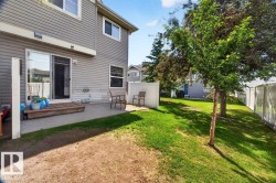Rear exterior featuring gray siding, a concrete patio, and a wood-finish deck - 