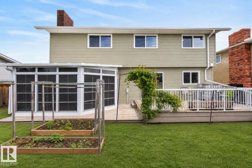 Expansive green lawn with a multi-level wood deck featuring white railings - 2712 104 Street, Edmonton, AB 