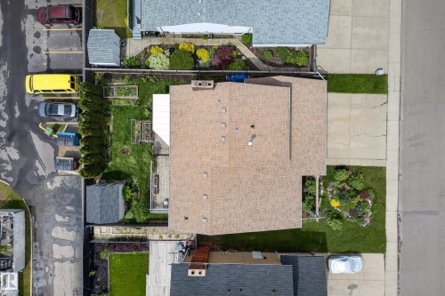 Aerial view showcasing a property with a light-colored shingle roof, green lawn areas, and established garden beds - 2712 104 Street, Edmonton, AB 