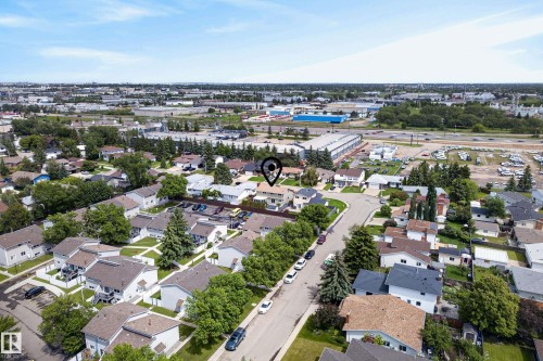 Aerial perspective of a residential community featuring numerous single-family homes with pitched roofs, mature trees, and paved streets - 2712 104 Street, Edmonton, AB 