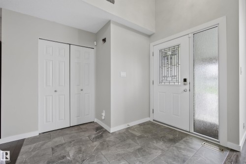 Entryway featuring a decorative frosted glass front door and a full-length frosted glass sidelight - 2712 104 Street, Edmonton, AB 