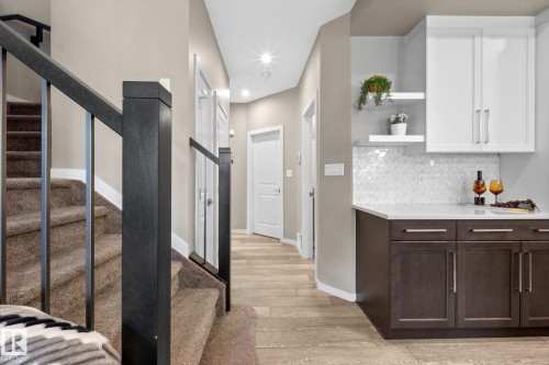 Modern staircase with dark wood-finish newel posts and metal balusters - 2146 Koshal Way, Edmonton, AB 