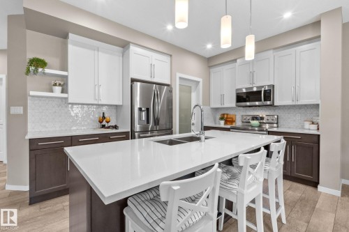Modern kitchen featuring an expansive island with white countertop - 2146 Koshal Way, Edmonton, AB 