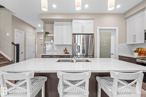 Kitchen island featuring a double-basin undermount sink with a gooseneck faucet - 2146 Koshal Way, Edmonton, AB 