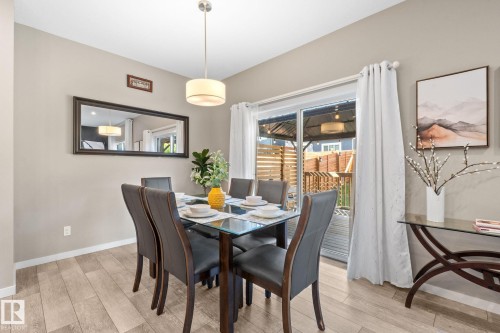 Dining area with wood-finish flooring, a contemporary pendant light fixture, and light-toned wall paint - 2146 Koshal Way, Edmonton, AB 