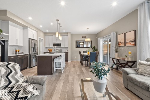 Open-concept interior featuring light wood-finish flooring throughout - 2146 Koshal Way, Edmonton, AB 