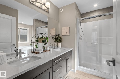 Bathroom featuring a dual-sink vanity with quartz countertop and dark wood-finish cabinetry - 2146 Koshal Way, Edmonton, AB 