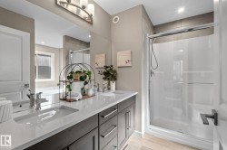Bathroom featuring a dual-sink vanity with quartz countertop and dark wood-finish cabinetry - 