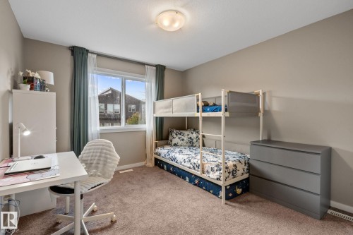 Carpeted room featuring a double-paned window with white trim, neutral wall tones, and a ceiling-mounted light fixture - 2146 Koshal Way, Edmonton, AB 