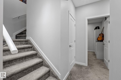 Carpeted staircase with white handrail and baseboards - 2146 Koshal Way, Edmonton, AB 