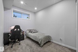Carpeted room featuring a white-framed egress window and recessed lighting - 