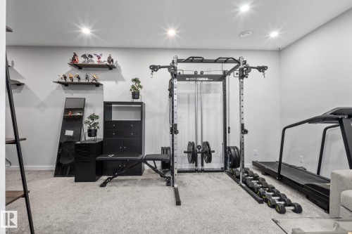 Carpeted room featuring recessed lighting, light gray walls, and dark floating shelves - 2146 Koshal Way, Edmonton, AB 