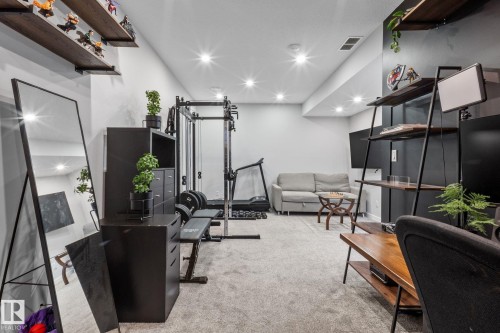 Recessed lighting illuminates a versatile space featuring light gray carpeting and white walls - 2146 Koshal Way, Edmonton, AB 