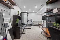 Recessed lighting illuminates a versatile space featuring light gray carpeting and white walls - 
