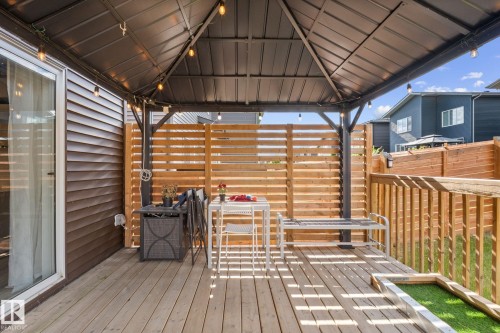 Wood-finish deck featuring a dark metal gazebo with string lighting - 2146 Koshal Way, Edmonton, AB 