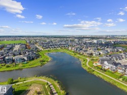 Expansive residential community featuring a prominent lake, extensive green spaces, and paved walking paths - 