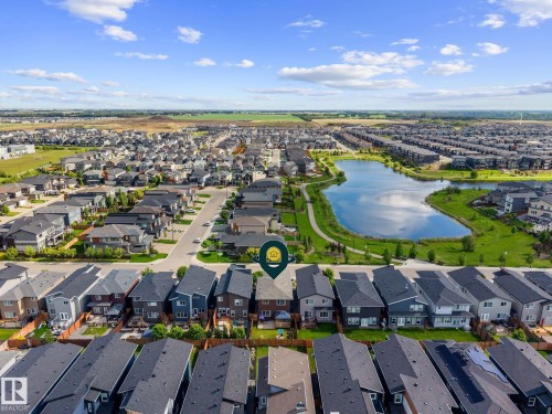 Aerial perspective showcasing a residential development with a prominent central lake and green spaces - 2146 Koshal Way, Edmonton, AB 