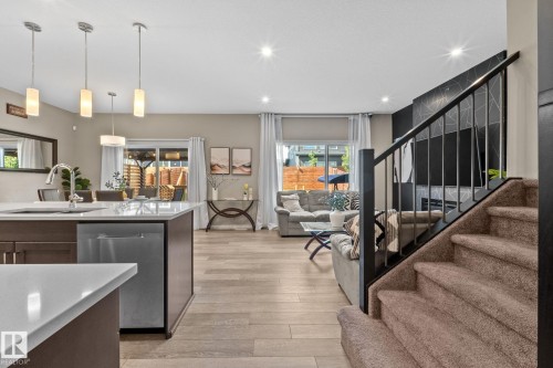 Open-concept living space with light wood-finish flooring - 2146 Koshal Way, Edmonton, AB 