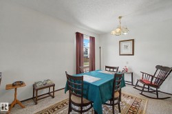 Dining area featuring a window with brown drapery, a brass-finish chandelier, and light-colored flooring - 