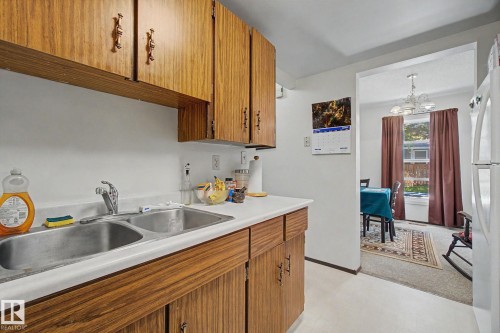 Kitchen featuring wood-finish cabinetry and white countertops - 18409 66 Avenue, Edmonton, AB 