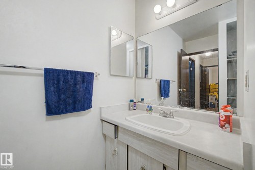 Bathroom vanity featuring a white countertop with an integrated sink and chrome faucet - 18409 66 Avenue, Edmonton, AB 