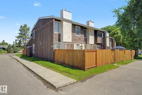 Townhome exterior featuring vertical wood siding and stucco accents - 18409 66 Avenue, Edmonton, AB 