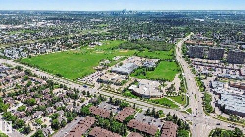 Expansive aerial overview of a vibrant urban landscape, featuring diverse residential areas, commercial buildings, and extensive green spaces - 18409 66 Avenue, Edmonton, AB 