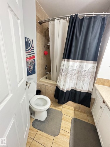 Ceramic tile flooring, white panel door, and white vanity with stone-look countertop - 45 Lambert Crescent, St. Albert, AB 