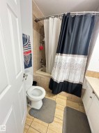 Ceramic tile flooring, white panel door, and white vanity with stone-look countertop - 