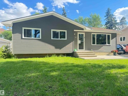 Ranch-style exterior featuring horizontal siding, a light-colored entry door, and white-framed windows - 45 Lambert Crescent, St. Albert, AB 