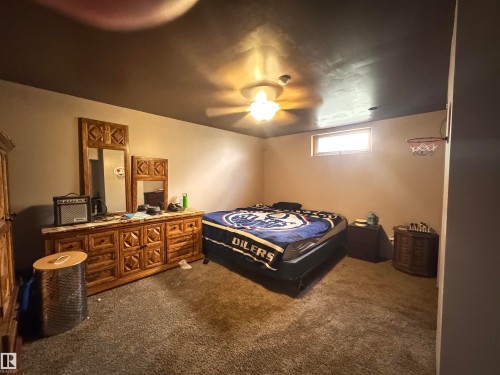 Carpeted room featuring a ceiling fan with integrated lighting, a high-set window, and painted walls - 45 Lambert Crescent, St. Albert, AB 