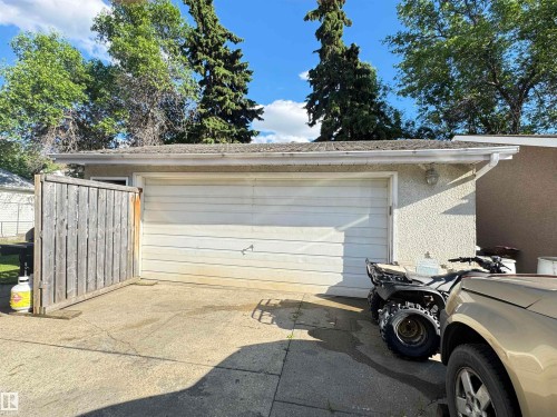 Detached garage with a paneled door, stucco exterior, and rain gutters - 45 Lambert Crescent, St. Albert, AB 