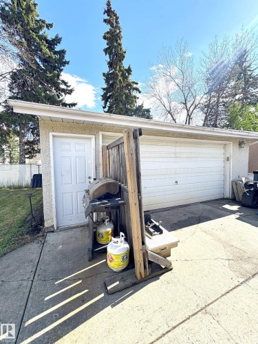 Attached two-car garage featuring a white overhead door and a side entry door - 45 Lambert Crescent, St. Albert, AB 