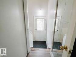 Entryway featuring a decorative glass panel door, light wood-finish flooring, and a mirrored closet door - 