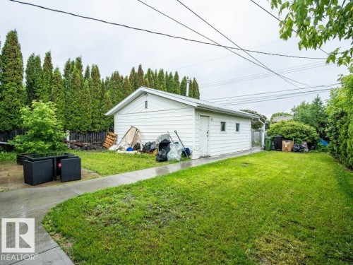 Detached garage with white siding, multiple windows, and a side door access - 7515 130 Avenue, Edmonton, AB 